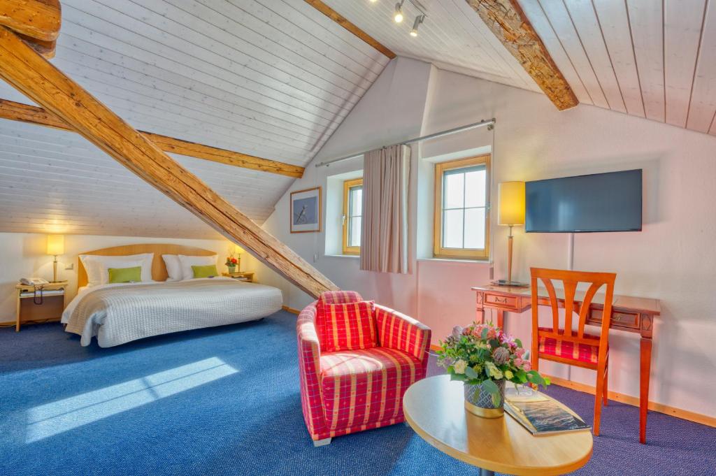 una camera con letto, tavolo e sedia di Hôtel Bon Rivage a Vevey