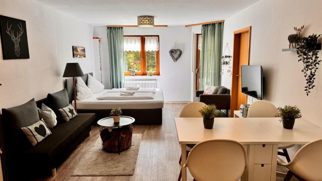 a living room with a couch and a bed at Waldtwin 2 Titisee - Balkon mit Naturblick - Seenähe 5 Minuten in Titisee-Neustadt