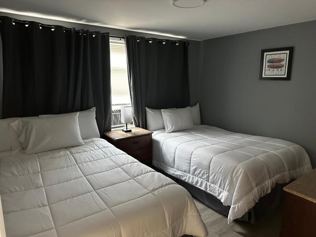 ein Schlafzimmer mit zwei Betten und einem Fenster in der Unterkunft Atlantic Breeze Motel &amp; Apartments in Ocean City