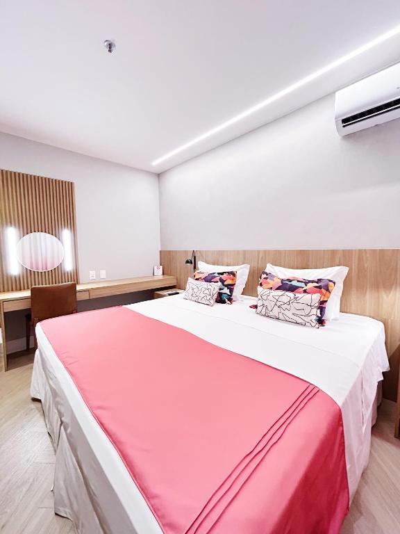 a bedroom with a large bed with a pink blanket at Mar Ipanema Hotel in Rio de Janeiro