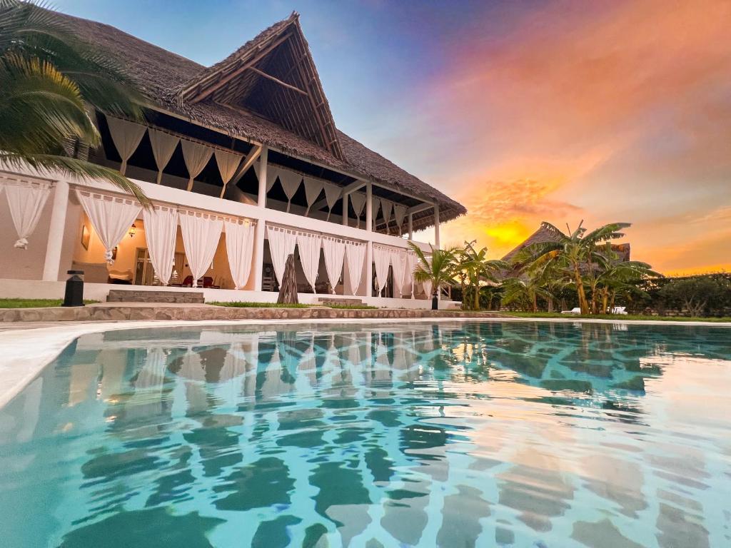 a resort swimming pool in front of a building at WEBER LUXURY APARTMENTS KENYA - Maisha Resort in Watamu
