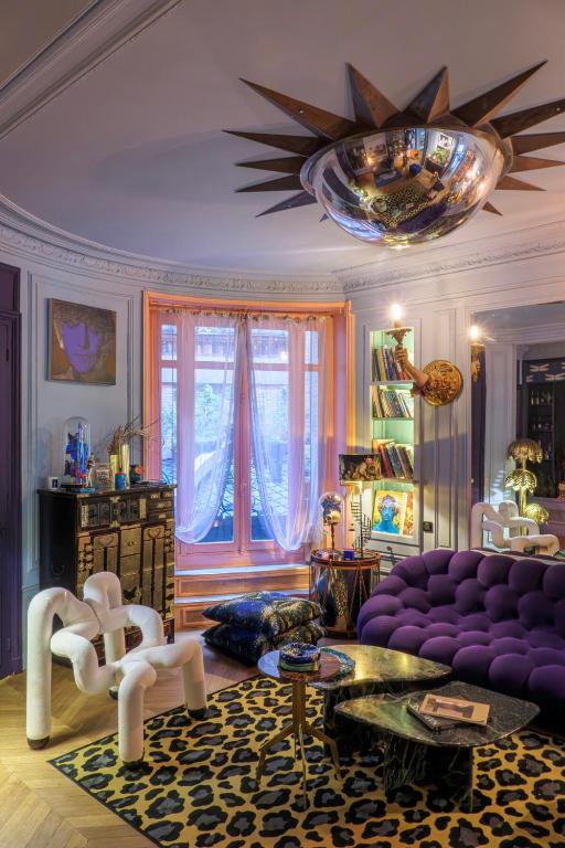 - un salon avec un canapé violet et un lustre dans l'établissement Large Boheme creative flat below Montmartre, à Paris