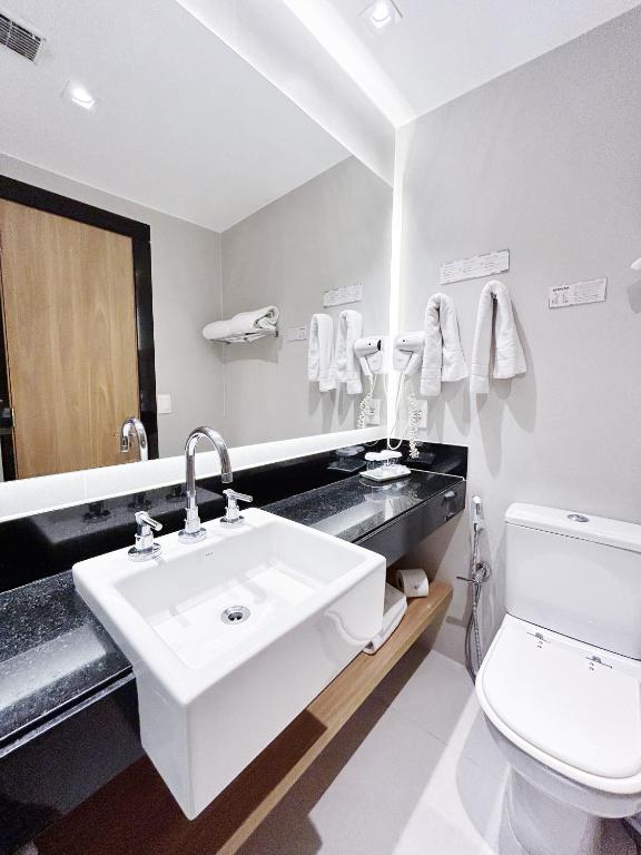 a bathroom with a sink and a toilet and a mirror at Mar Ipanema Hotel in Rio de Janeiro