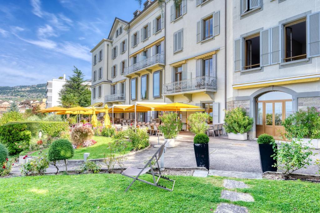 un hotel con prato di fronte a un edificio di Hôtel Bon Rivage a Vevey