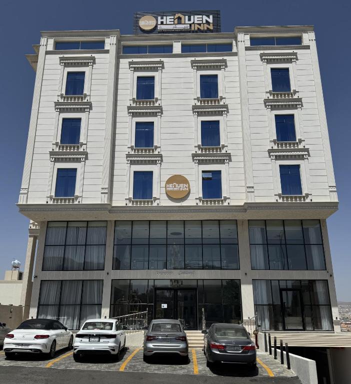 a building with cars parked in front of it at هيفين إن للشقق المخدومة -ثروات ابها in Abha