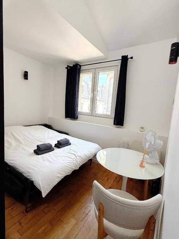 une petite chambre avec un lit et une table dans l'établissement Stylish Loft Studio in Central Paris in Clery 4, à Paris