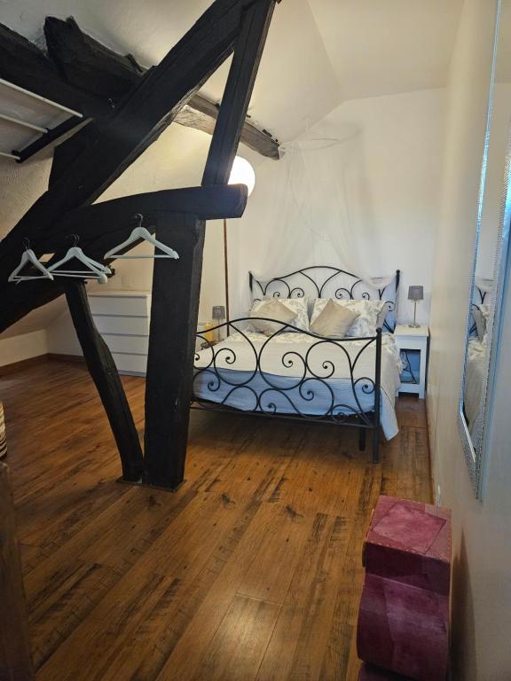 a bedroom with a bed and a wooden floor at Butterfly Cottage in Pouilly-sur-Loire