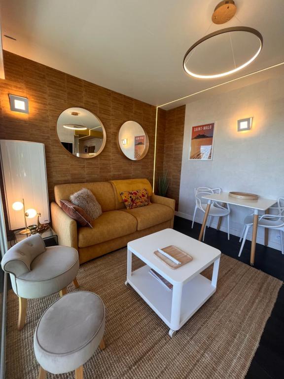 a living room with a couch and a table at Le Cézembre, au pied de la plage in Saint Malo