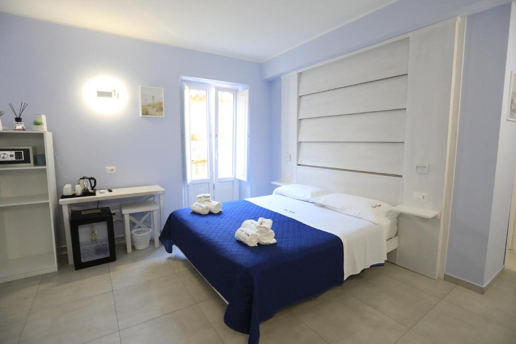 a bedroom with a bed with two stuffed animals on it at Don Peppe Rooms With Beach Service Included in Tropea