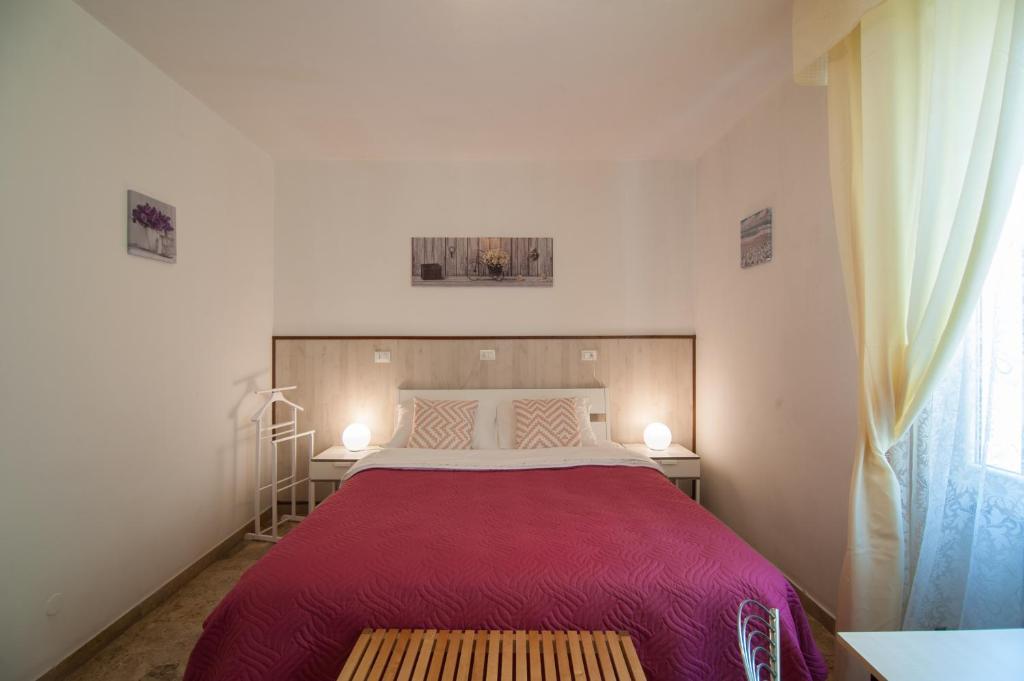 a bedroom with a large bed with a red blanket at 216 Venice in Mestre