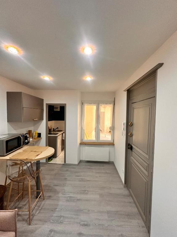 a kitchen with a table and a desk in a room at Studio 1 centre ville RDC in Bar-le-Duc