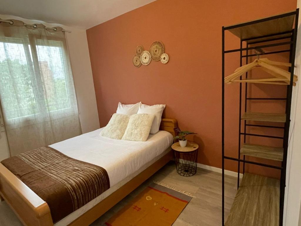 - une petite chambre avec un lit aux murs orange dans l'établissement Colorino - T4 Lumineux Cosy, Parking Gratuit, Commerces, à Saint-Brieuc