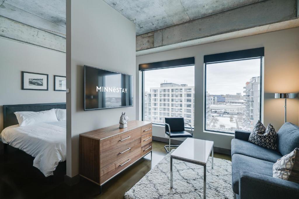a bedroom with a bed and a tv and a couch at Sable 602 - Alcove in Minneapolis