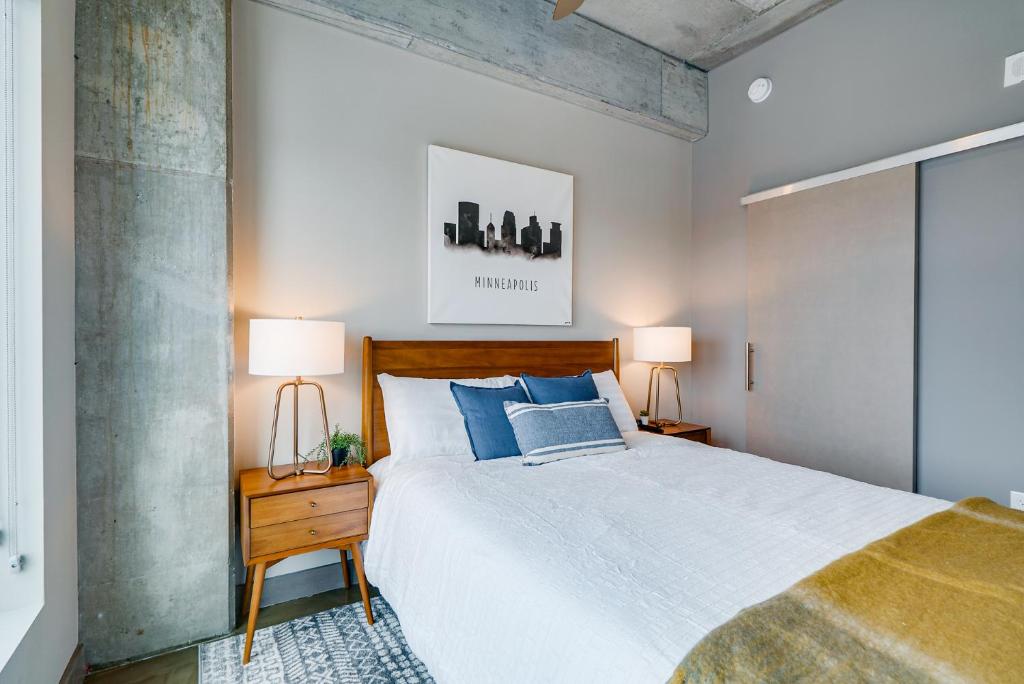 a bedroom with a bed with blue pillows and two lamps at Sable 703 - Alcove in Minneapolis