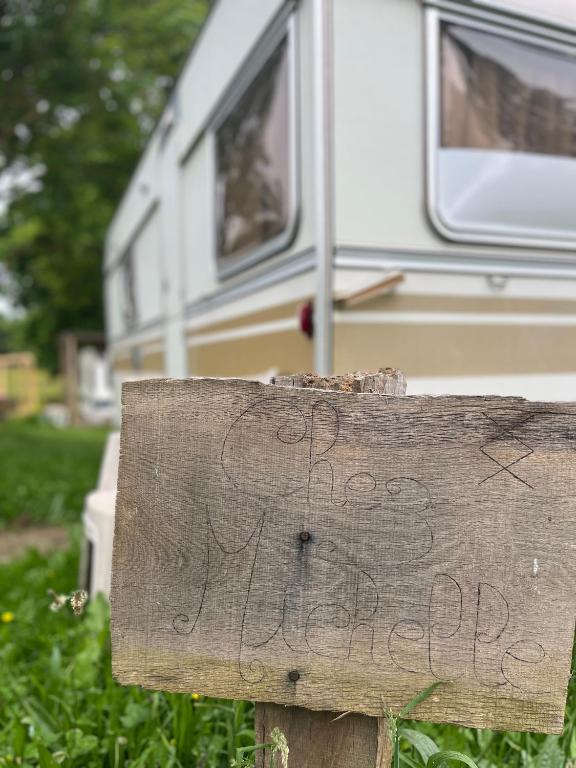 un panneau devant un camping-car avec une écriture manuscrite dessus dans l'établissement Séjour Bien Être nature, à Perrecy-les-Forges