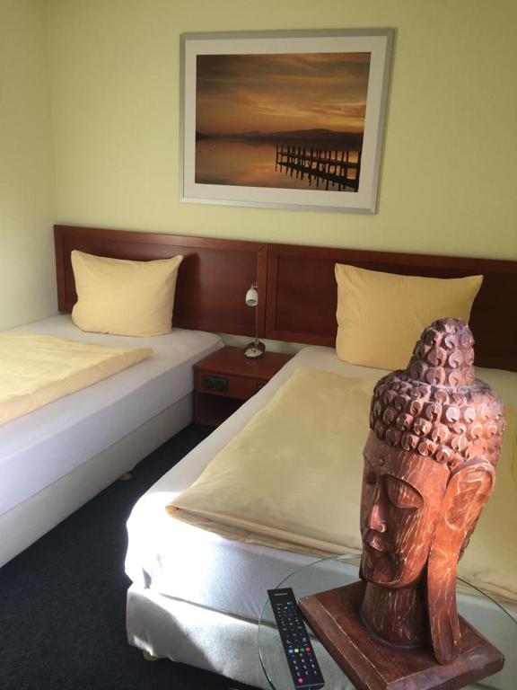 a room with two beds and a statue of a head at Hostel Apartment in Castrop-Rauxel