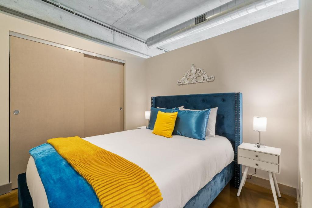 a bedroom with a bed with blue and yellow pillows at Sable 604 - One Bedroom in Minneapolis