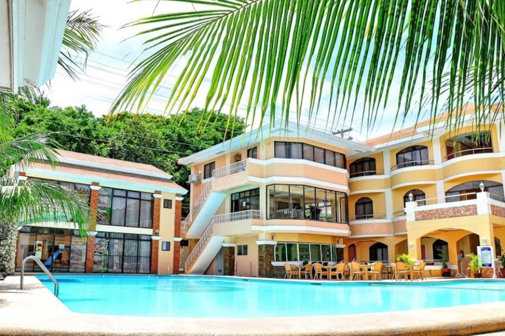 a hotel with a swimming pool in front of a building at Boracay Holiday Resort in Boracay