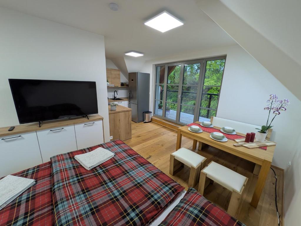 sala de estar con mesa y TV de pantalla plana en Apartmán A10 v centru Harrachova, en Harrachov