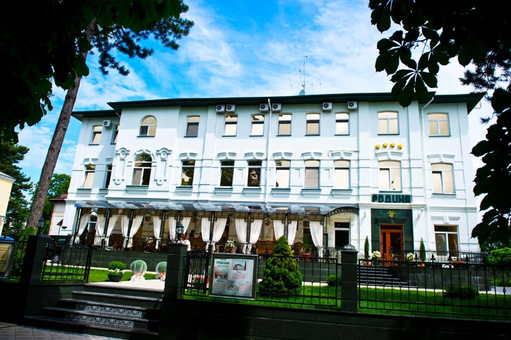 a white building with a fence in front of it at Pansionat Rodina in Essentuki