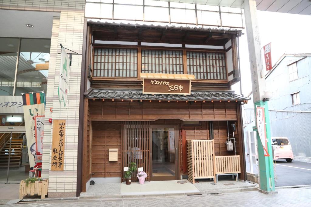 un edificio con un cartel en la parte delantera en Guesthouse Mikkaichi, en Komatsu