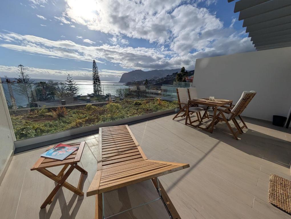 a balcony with a table and chairs and a view of the ocean at Breathtaking Oceanfront Living, Sunset Facing 3-Bedroom Flat in Acqua Residences in Funchal