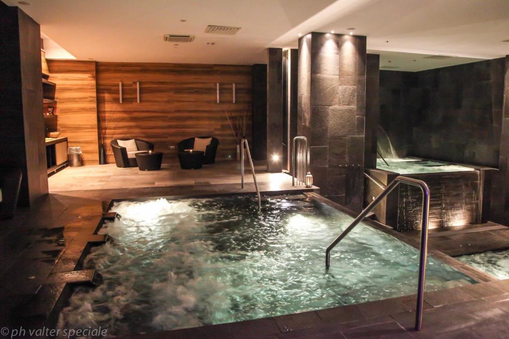 a jacuzzi tub in the middle of a room at 4 Spa Resort Hotel in Catania