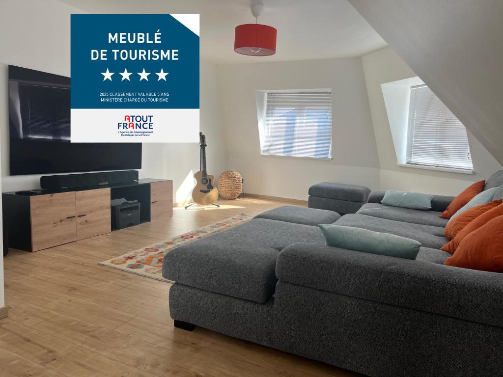 un salon avec un canapé et un panneau indiquant « multiple devioussie » dans l'établissement LE DONJON Classé 4 étoiles Appartement 120 m2 5mn Centre Ville Au Calme, à Strasbourg