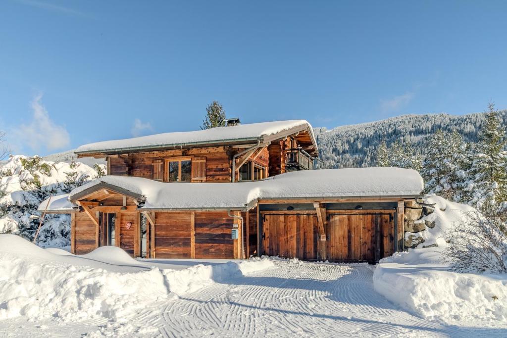 une cabane en rondins avec de la neige sur le toit dans l'établissement Family Cottage, Panoramic View, à Arâches-la-Frasse