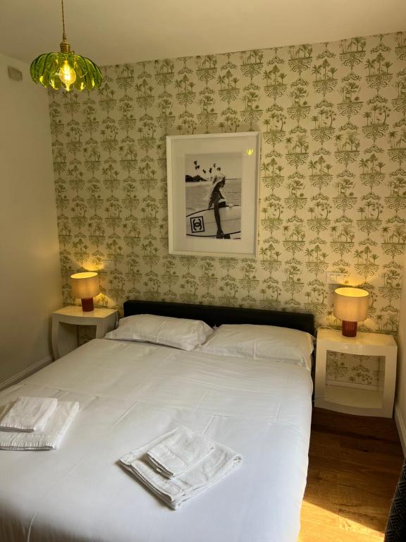 - une chambre dotée d'un lit blanc avec deux tables et deux lampes dans l'établissement Maison d' Orange - Chambres, à Saint-Tropez