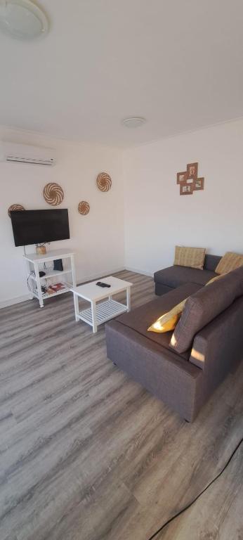 a living room with a couch and a table at Sea, Sun and Wild Nature in Costa de Santo André