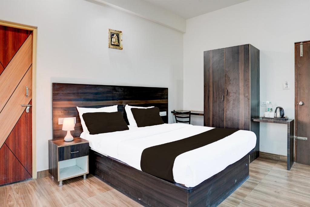 a bedroom with a large bed with a wooden headboard at Hotel O Royal galaxy suites in Bengaluru