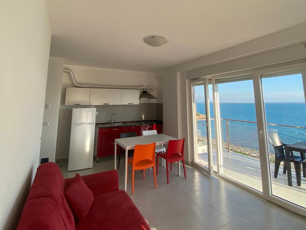 a living room with a red couch and a table with chairs at BlueWaveapartments 2 in Shëngjin