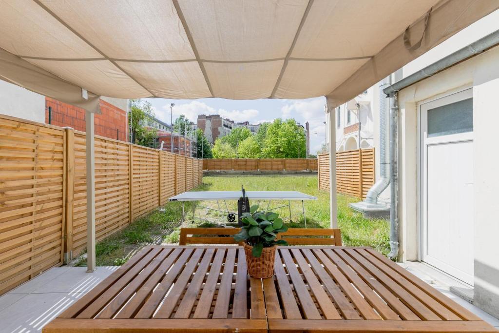 d'une terrasse avec une table en bois et une table de pique-nique. dans l'établissement Play ping pong in your magical garden in Paris, à Paris
