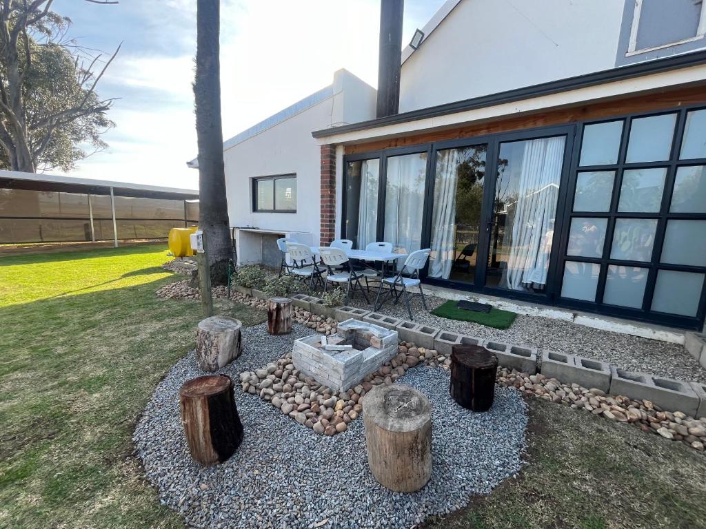 a house with a patio with a bunch of logs at Hephzibah Inn Farm Cottage in Hermon