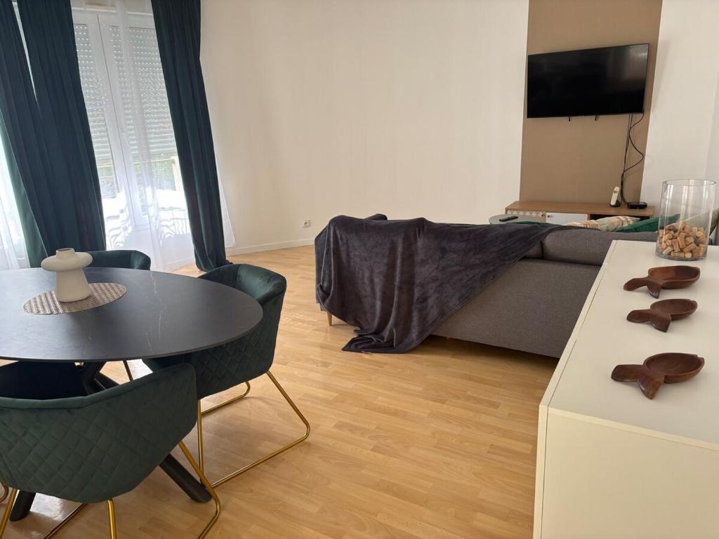 un salon avec une table et un canapé dans l'établissement Bel appart 3 ch centre et parking, à Tours