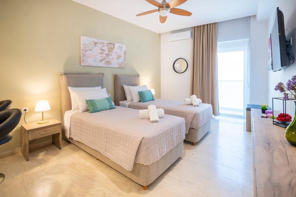 a bedroom with two beds and a flat screen tv at Diamond Apartments 4 in Kardamaina