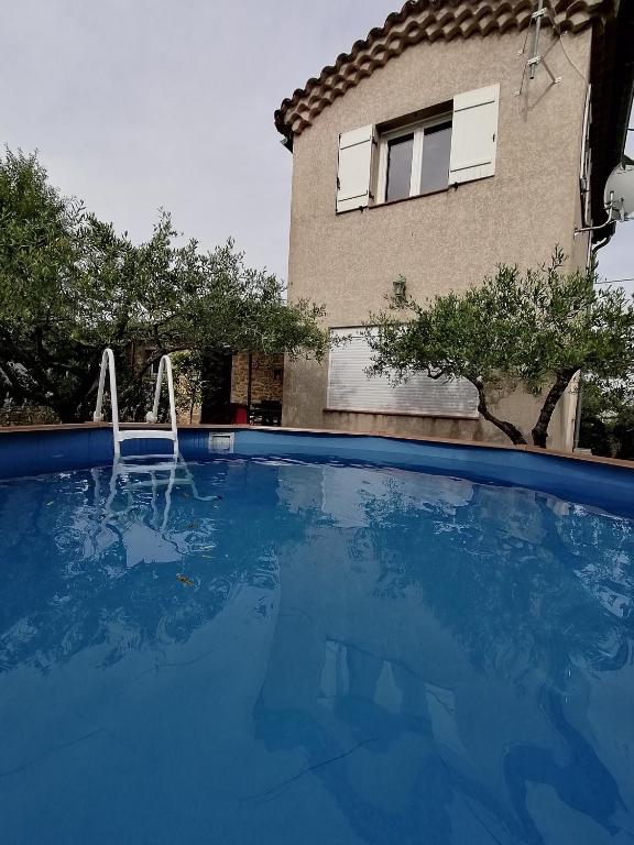 une grande piscine bleue devant un immeuble dans l'établissement Charmante petite Villa, à Boisset-et-Gaujac