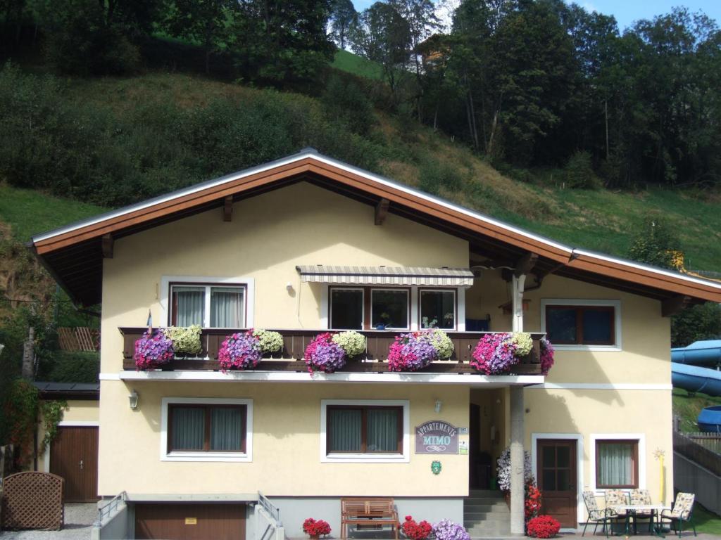 ein Haus mit Blumenkästen auf dem Balkon in der Unterkunft MIMO Appartements in Saalbach-Hinterglemm