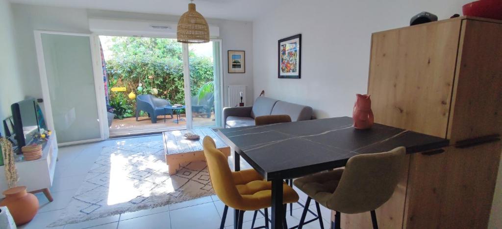 une cuisine avec une table et des chaises dans une pièce dans l'établissement Vivre le Bassin !, à La Teste-de-Buch