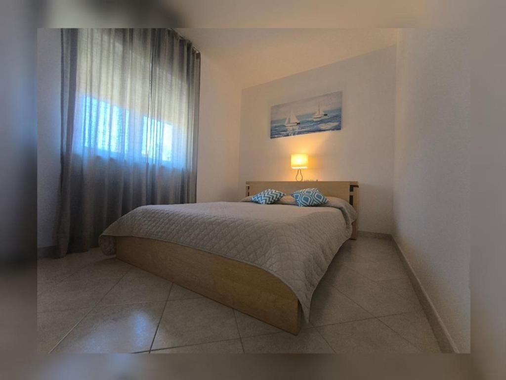 a bedroom with a bed with a lamp and a window at Pizzo Beach Club Luxury Apartment in Pizzo