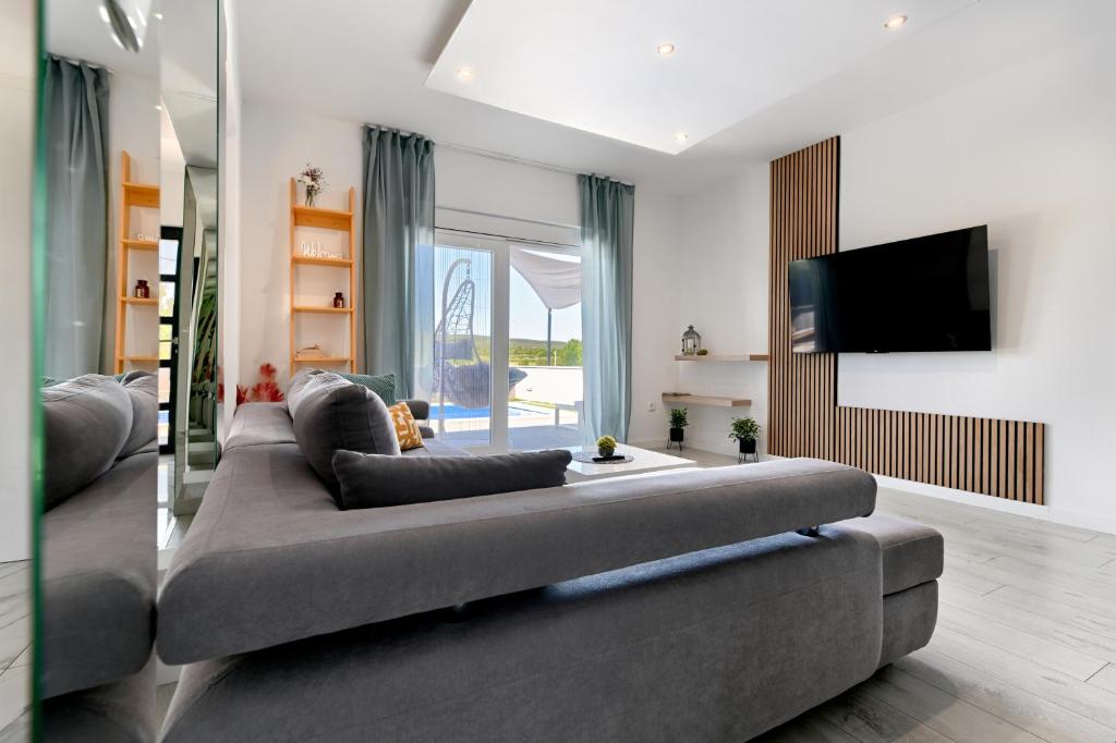 Televízia a/alebo spoločenská miestnosť v ubytovaní Luxurious Villa Natali
