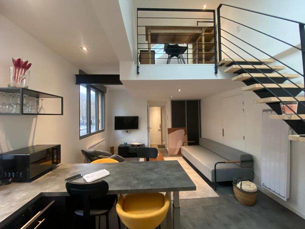 un salon avec un escalier dans un loft dans l'établissement au Zen'Hit 10 Lille centre Grand Palais, à Lille