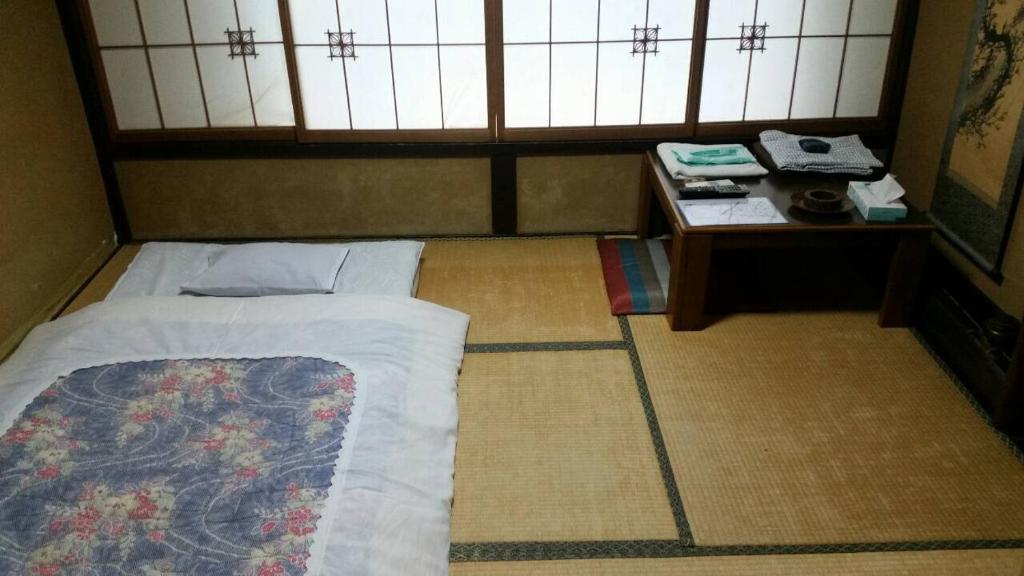 Postel nebo postele na pokoji v ubytování Tobaya Ryokan