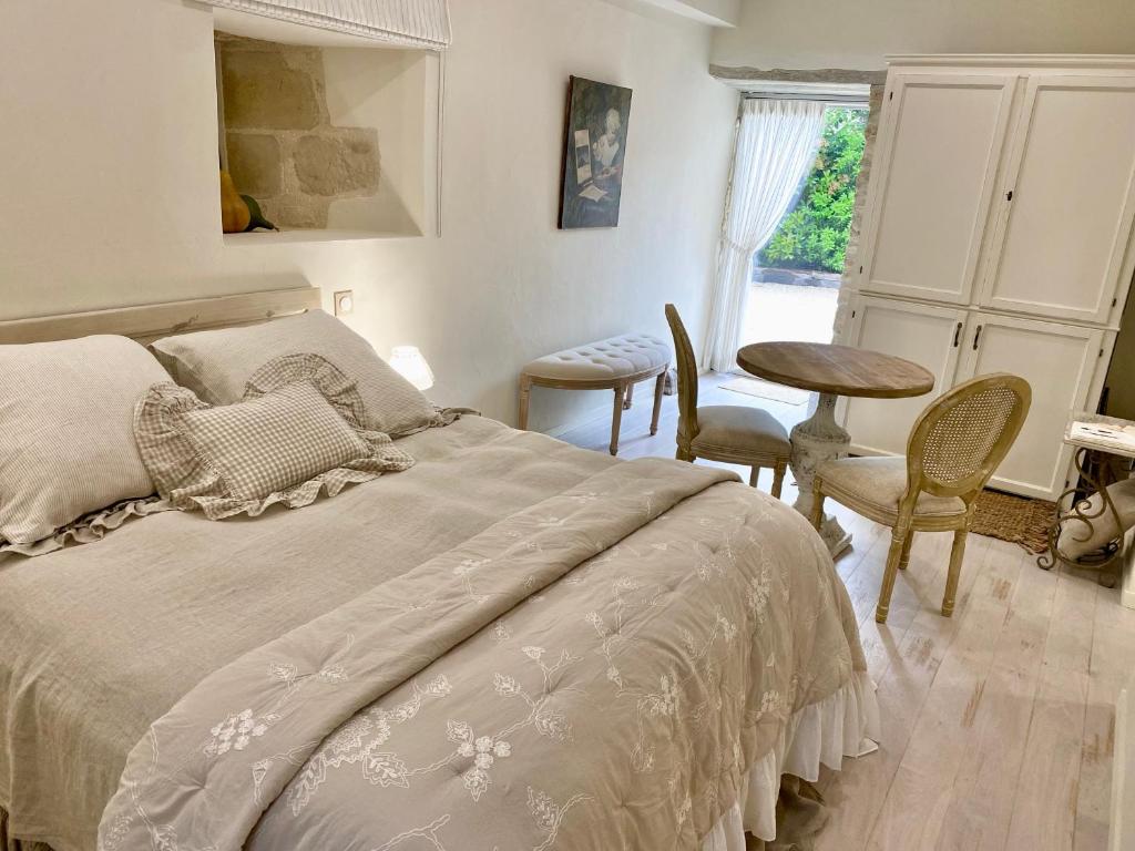 une chambre avec un lit, une table et des chaises dans l'établissement Le Boudoir de Syssi, à Saint-Rabier