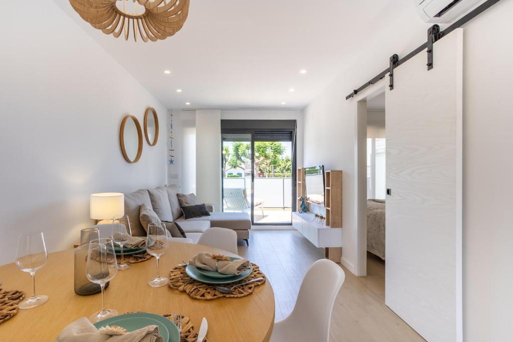 Un comedor y una sala de estar con mesa y sillas. en Sunrise House MET Oliva nova, en Oliva