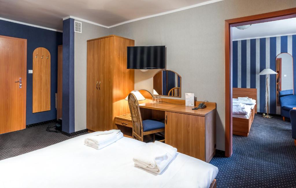 pokój hotelowy z biurkiem i sypialnią w obiekcie Baltic Inn w Pogorzelicy