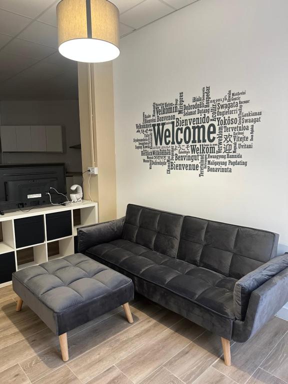 a black leather couch in a living room with a wall at Apartamento tipo loft valencia in Paiporta