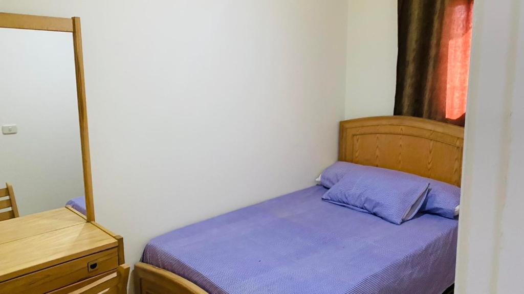 a small bedroom with a bed and a mirror at شاليه لاسرينا العين السخنه in Ain Sokhna