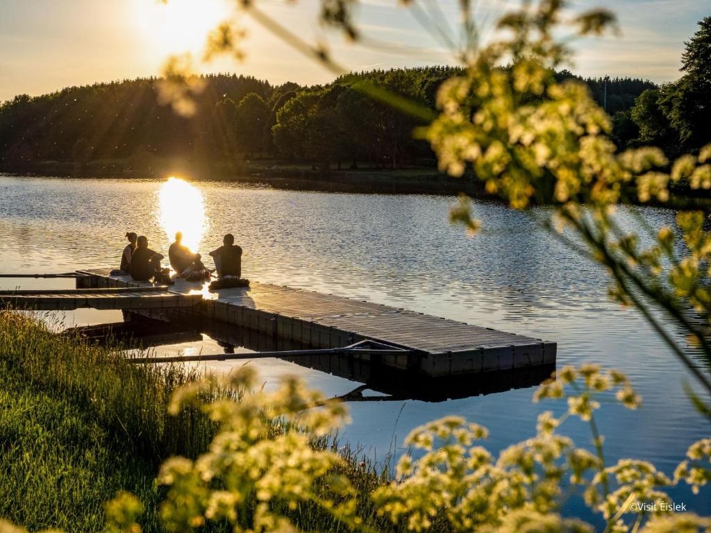 a group of people sitting on a dock on a lake at Anatura Luxembourg in Weiswampach
